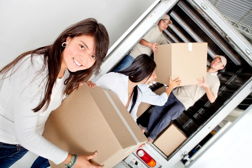Mover handling boxes and household items near Colliers Wood